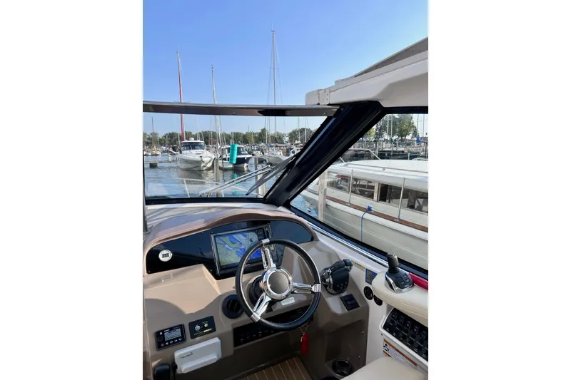 Slide: The Image of Cockpit view of 2018 Regal 35 Sport Coupe at marina, featuring steering wheel and navigation display. - 8