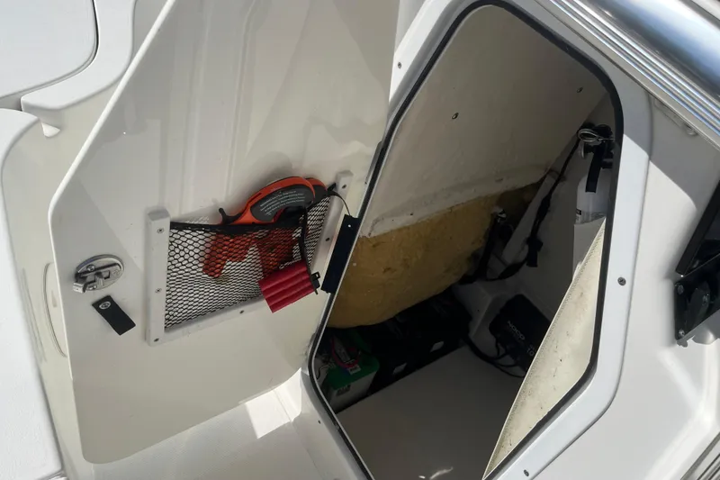 Slide: The Image of 2019 Sea Hunt BX 22 BR storage compartment with safety equipment and accessories. - 14