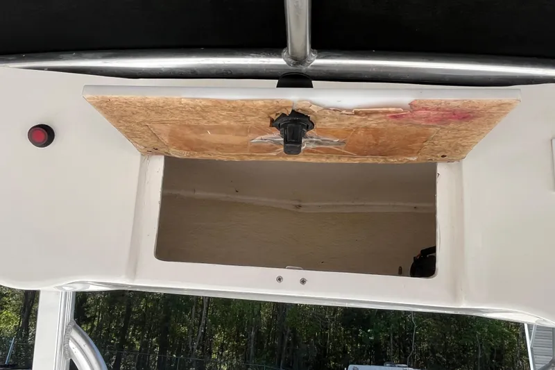Slide: The Image of 2019 Sea Hunt BX 22 BR boat compartment with open wooden hatch and visible interior. - 19