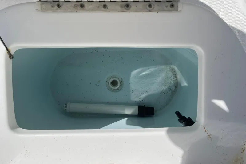 Slide: The Image of Livewell compartment of a 2019 Sea Hunt BX 22 BR boat, featuring a drain and pipe. - 32