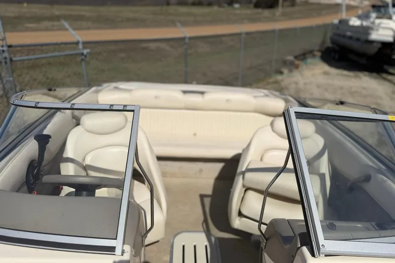 Slide: The Image of 2004 Crownline 180 BR boat interior with beige seating and windshield. - 1