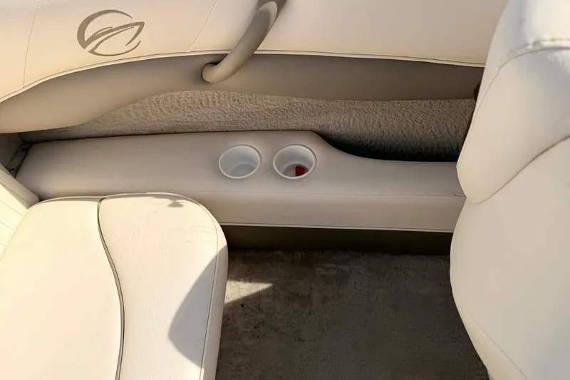 Slide: The Image of Interior of 2004 Crownline 180 BR boat with cup holders and beige seating. - 12