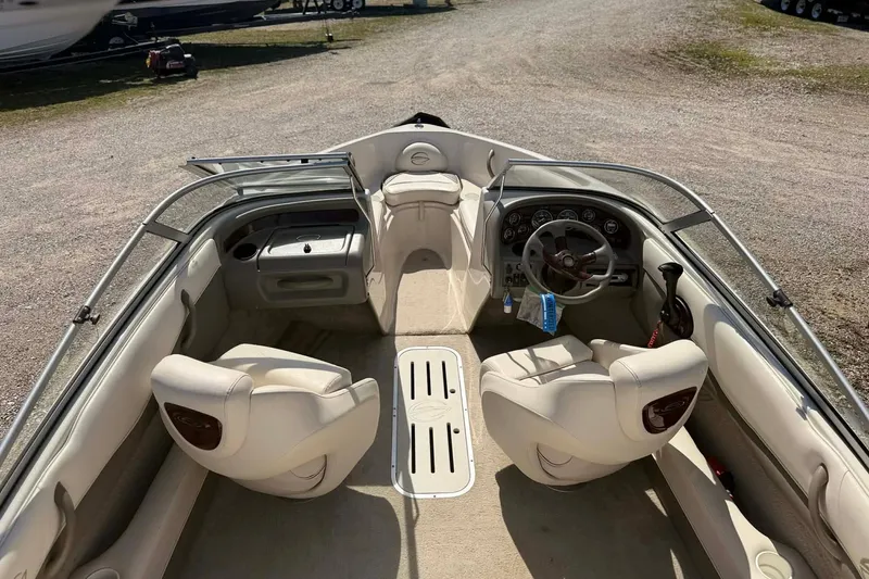 Slide: The Image of 2004 Crownline 180 BR boat interior with beige seating and steering wheel. - 13