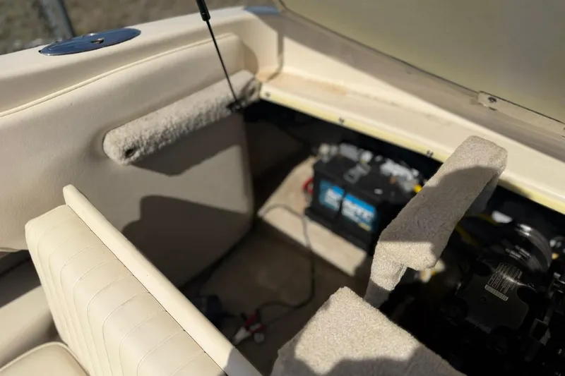 Slide: The Image of 2004 Crownline 180 BR boat interior showing battery compartment and seating area. - 5