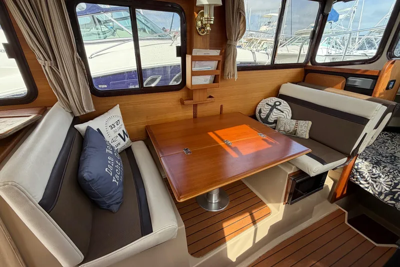 Slide: The Image of Interior of 2017 Ranger Tugs R-27 with cozy seating and wooden table. - 14