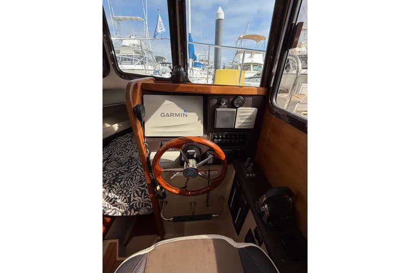 Slide: The Image of Interior helm of 2017 Ranger Tugs R-27 with Garmin navigation system and wooden steering wheel. - 18