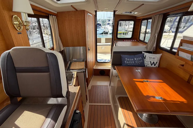 Slide: The Image of Interior of 2017 Ranger Tugs R-27 boat with wood finishes and seating area. - 19