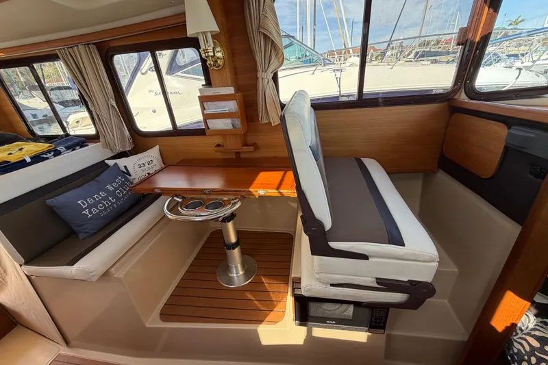 Slide: The Image of Interior of 2017 Ranger Tugs R-27 boat with seating and wooden table. - 23