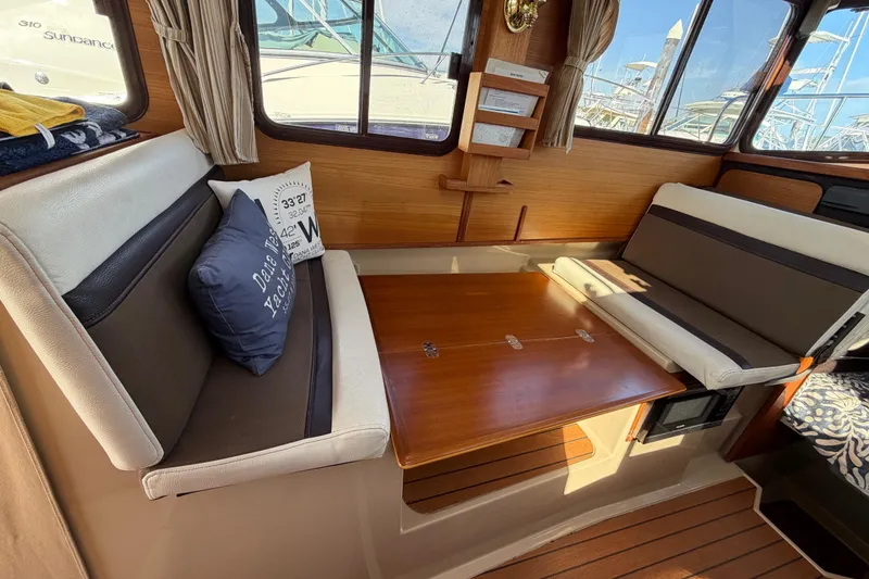 Slide: The Image of Interior of 2017 Ranger Tugs R-27 with cozy seating and wooden table. - 24