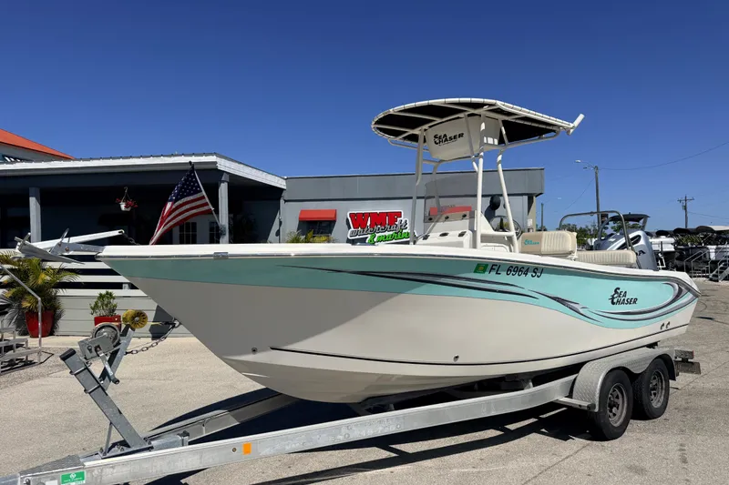 The Image of 2015 Sea Chaser 22 HFC boat on trailer, displayed outdoors with American flag. - 1