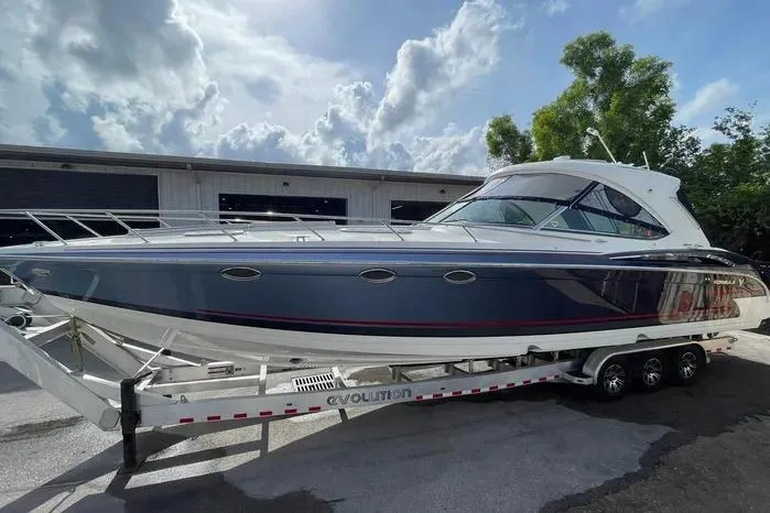 The Image of 2017 Formula 400 Super Sport boat on trailer, parked outdoors under cloudy sky. - 1