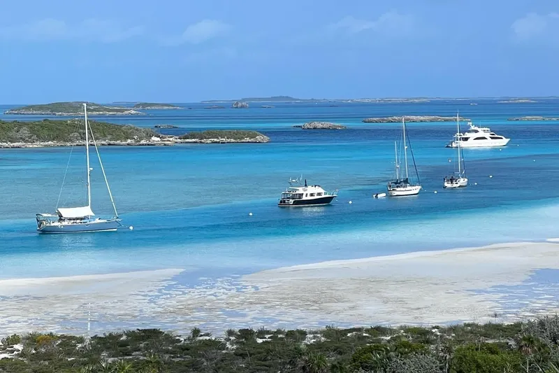 Slide: The Image of Boats anchored in clear turquoise waters, featuring a 2015 Coastal Craft 45. - 12