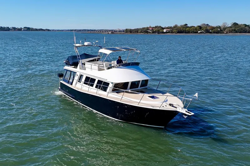 Slide: The Image of 2015 Coastal Craft 45 yacht cruising on serene waters under a clear blue sky. - 2