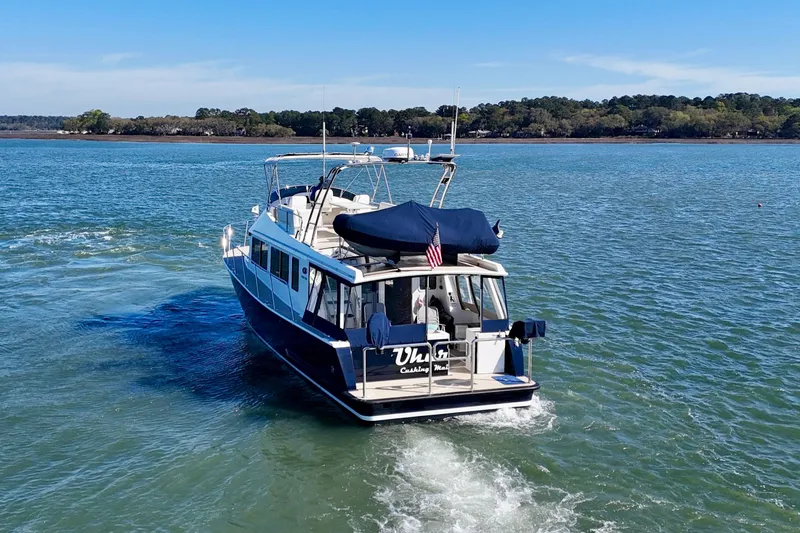 Slide: The Image of 2015 Coastal Craft 45 yacht cruising on a serene lake under a clear blue sky. - 7