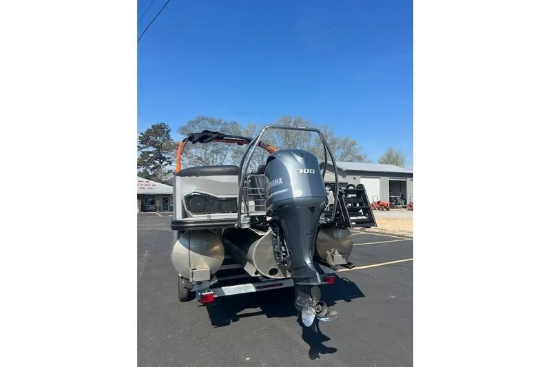 Slide: The Image of 2024 Bennington 23 RXFBA pontoon boat with Yamaha 300 outboard motor, parked outdoors. - 3