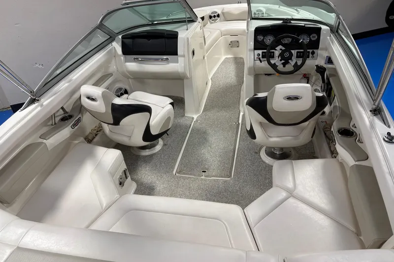 Slide: The Image of 2011 Chaparral 216 SSi boat interior with white seating and modern dashboard. - 10
