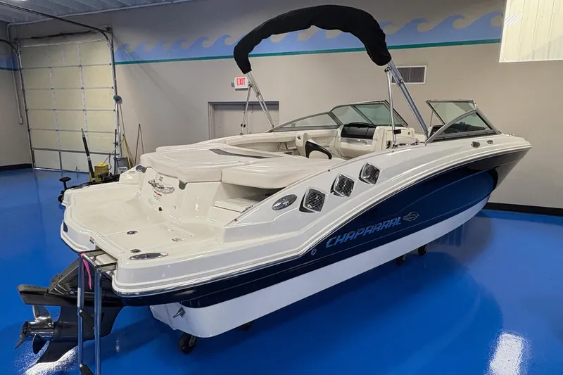 Slide: The Image of 2011 Chaparral 216 SSi boat in showroom, featuring sleek design and blue accents. - 2