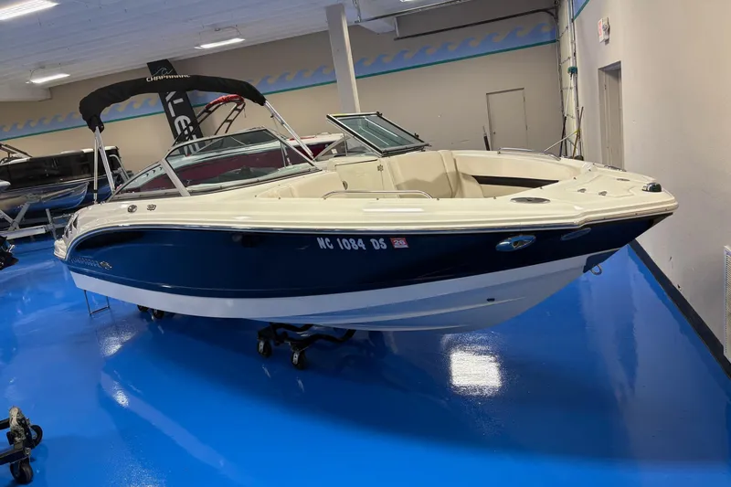 Slide: The Image of 2011 Chaparral 216 SSi boat displayed indoors on a shiny blue floor. - 3