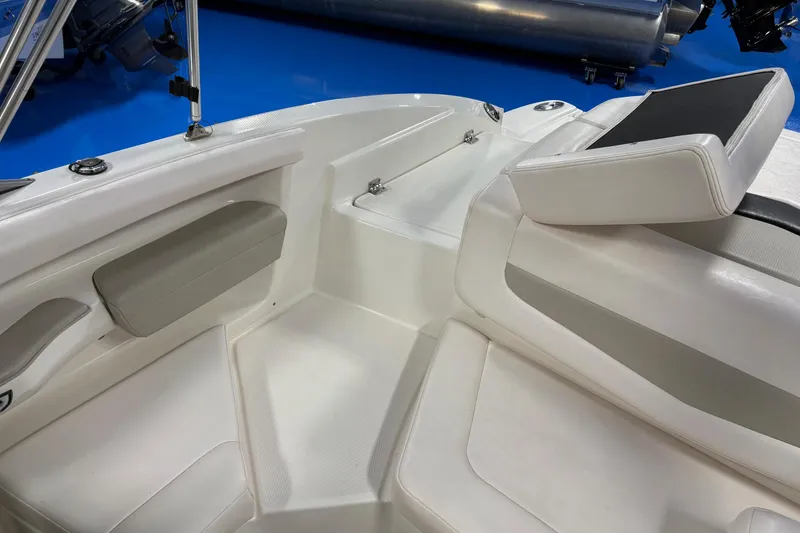 Slide: The Image of Interior view of a 2011 Chaparral 216 SSi boat, featuring white seating and sleek design. - 8