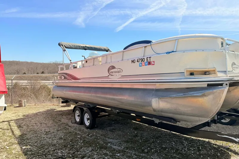 The Image of 2004 Lowe Jamaica 250 pontoon boat on trailer, parked outdoors under clear sky. - 1