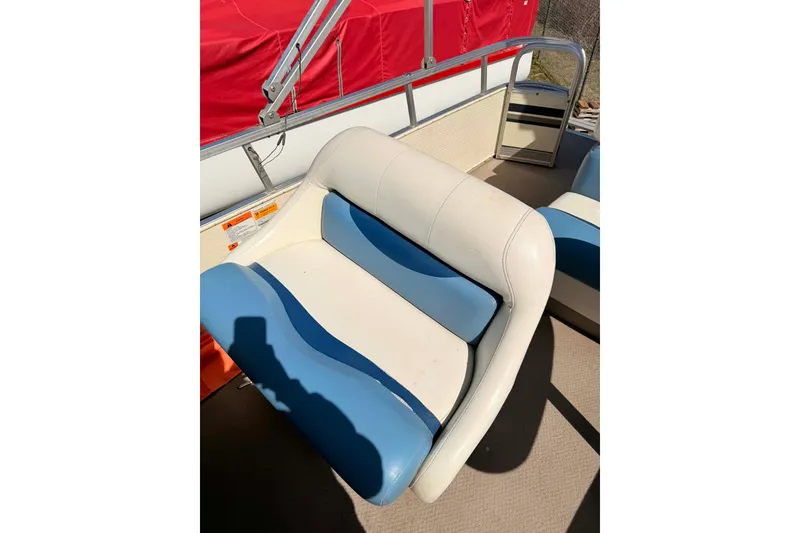 Slide: The Image of 2004 Lowe Jamaica 250 boat seat with blue and white upholstery, red cover in background. - 3