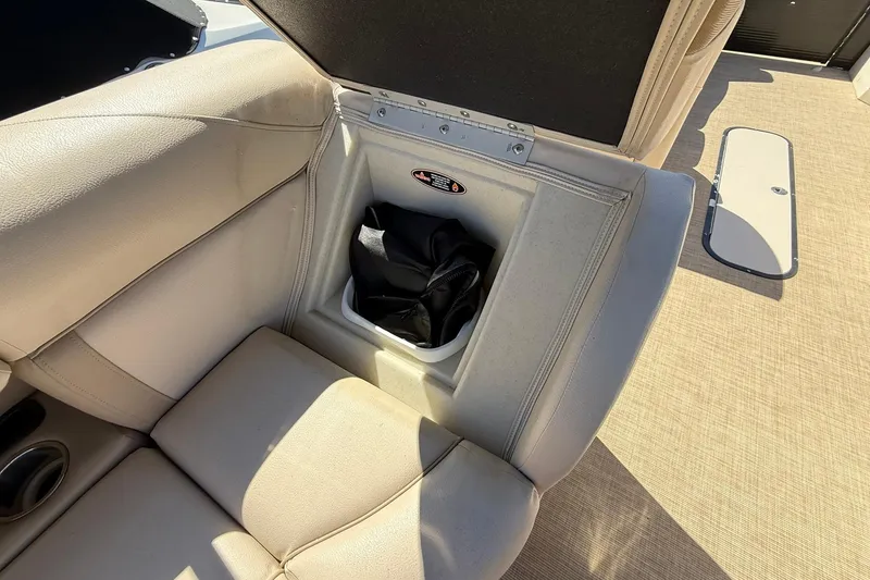 Slide: The Image of 2019 Harris Cruiser 250 boat seat storage compartment with beige upholstery. - 20