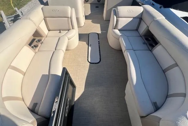 Slide: The Image of 2019 Harris Cruiser 250 pontoon boat with Mercury engine, parked outdoors under clear blue sky. - 5