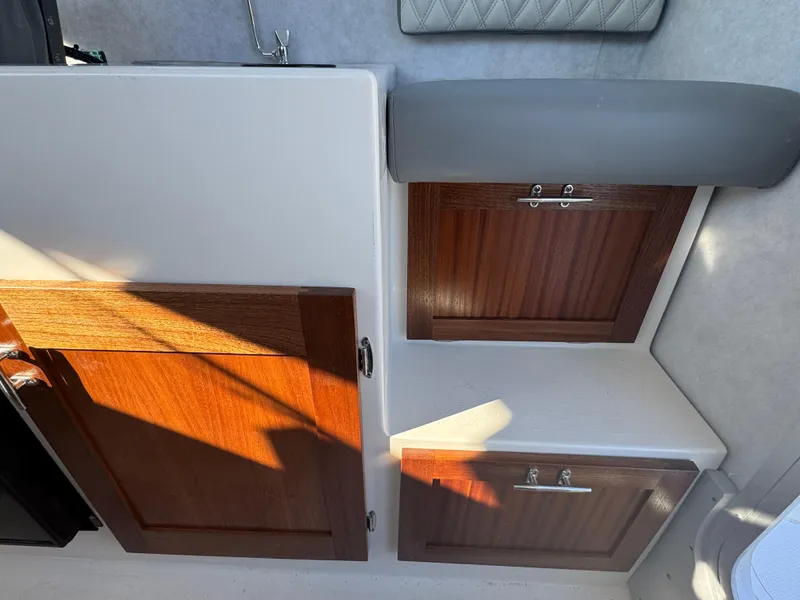 Slide: The Image of Interior view of 2025 Defiance San Juan 220 boat with wooden cabinets and seating. - 29