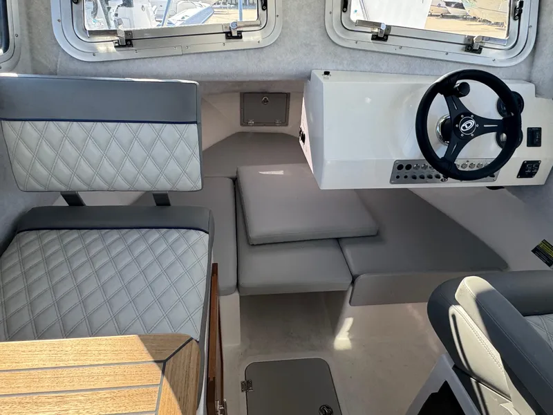 Slide: The Image of Interior of 2025 Defiance San Juan 220 boat with modern seating and steering wheel. - 33