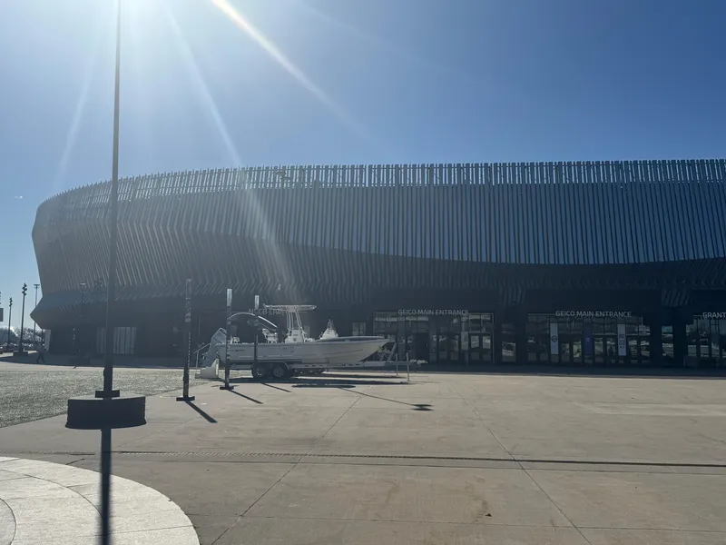 Slide: The Image of A Defiance San Juan 220 boat on a trailer outside a modern building under a clear blue sky. - 36