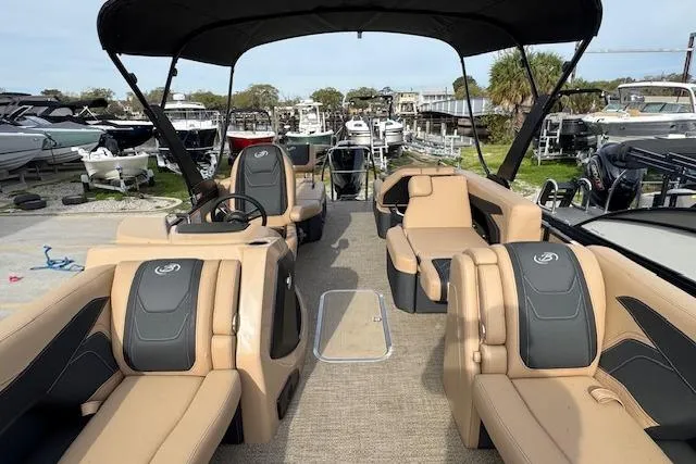 Slide: The Image of 2026 Barletta Cabrio 24M pontoon boat with spacious seating and canopy, docked at marina. - 22