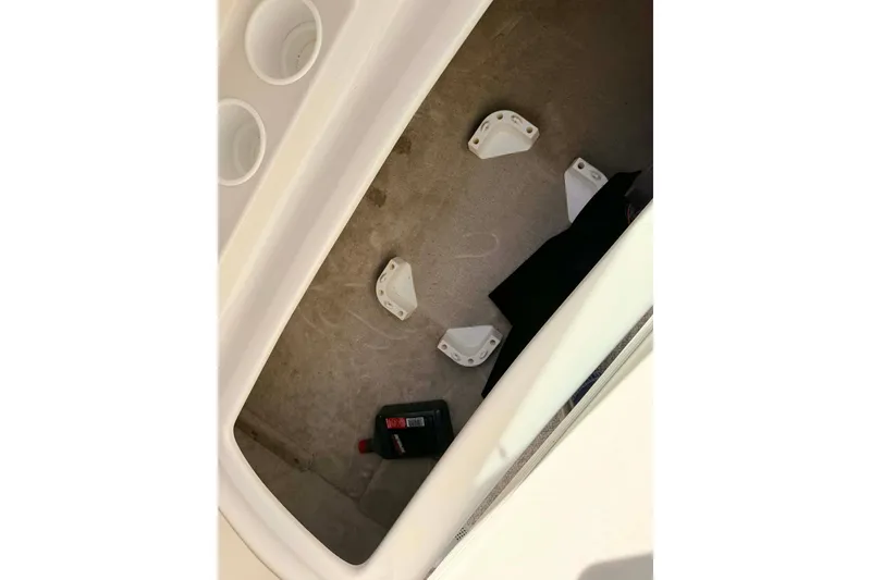 Slide: The Image of Storage compartment of a 2005 Crownline 270 BR boat with cup holders and oil container. - 13