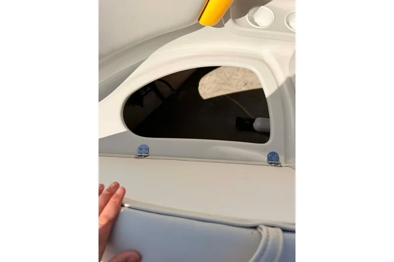 Slide: The Image of 2005 Crownline 270 BR boat interior with open storage compartment and visible hand. - 14