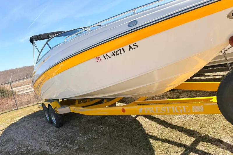Slide: The Image of 2005 Crownline 270 BR boat on yellow trailer, parked outdoors under clear sky. - 8