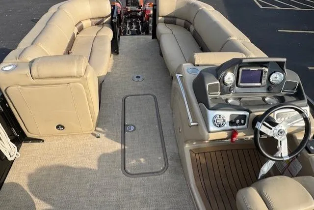 Slide: The Image of 2019 Regency 230 LE3 pontoon boat interior with beige seating and modern dashboard. - 12