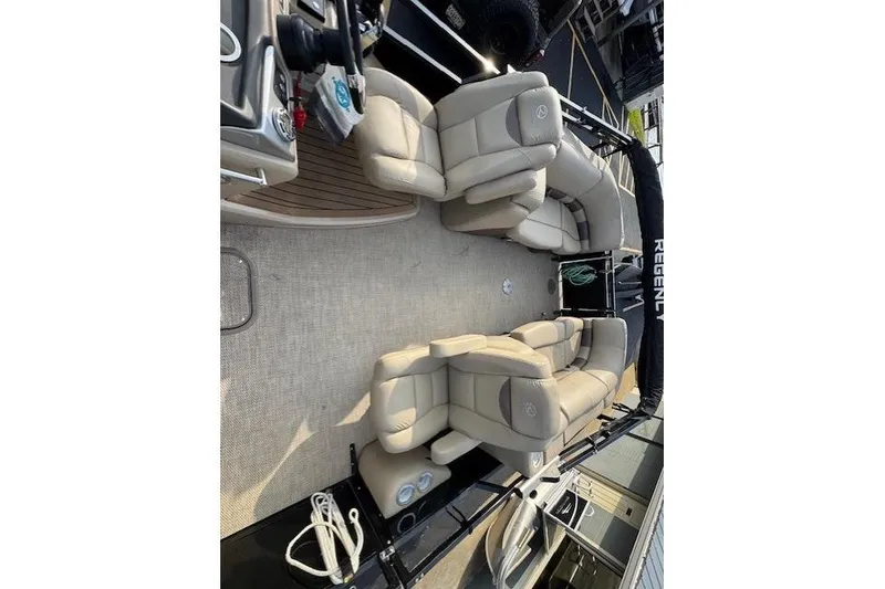 Slide: The Image of 2019 Regency 230 LE3 pontoon boat interior with beige seating and steering console. - 15