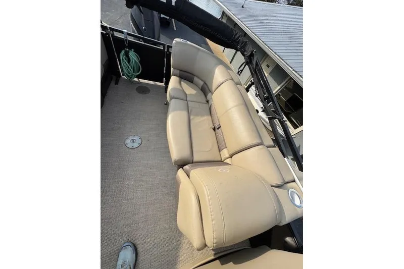 Slide: The Image of 2019 Regency 230 LE3 boat interior with beige leather seating and carpeted floor. - 16