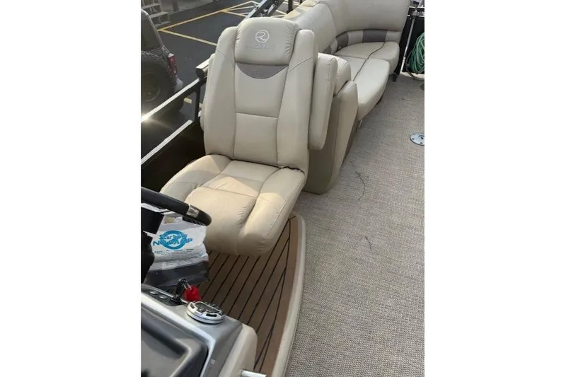 Slide: The Image of 2019 Regency 230 LE3 boat interior with beige seating and carpeted flooring. - 19