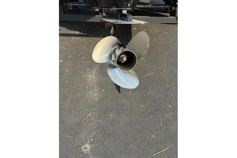 Slide: The Image of Close-up of a 2019 Regency 230 LE3 boat propeller on asphalt surface. - 24
