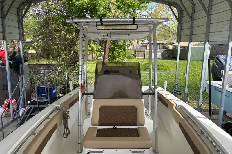Slide: The Image of 1999 Contender 21 Open boat under a metal canopy, featuring tan seating and console. - 13