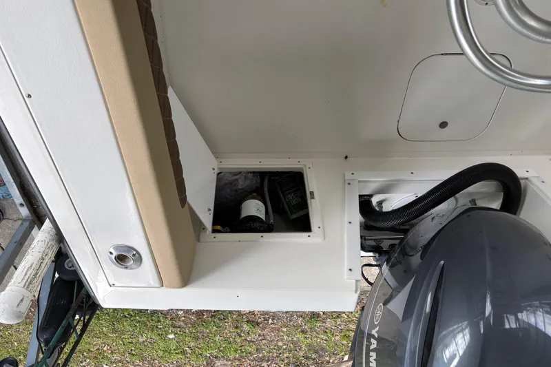 Slide: The Image of 1999 Contender 21 Open boat interior with storage compartments and Yamaha engine. - 19