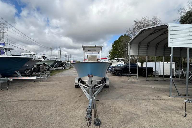 Slide: The Image of 1999 Contender 21 Open boat on trailer in outdoor storage lot under cloudy sky. - 3