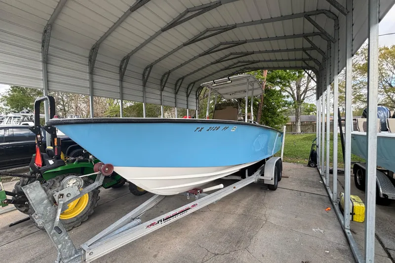 Slide: The Image of 1999 Contender 21 Open boat on trailer under metal canopy. - 6