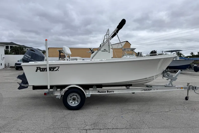 Slide: The Image of 2026 Parker 180 Coastal boat on trailer, parked outdoors under cloudy skies. - 11