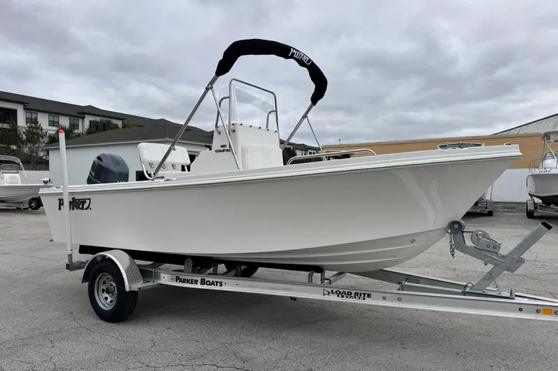 Slide: The Image of 2026 Parker 180 Coastal boat on trailer, displayed outdoors under cloudy skies. - 12