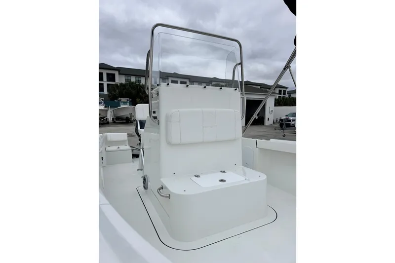 Slide: The Image of 2026 Parker 180 Coastal boat interior with seating and console, displayed outdoors. - 14