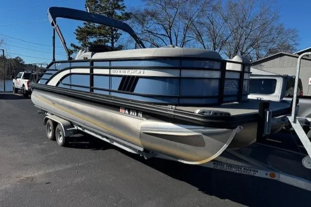 Slide: The Image of 2021 Bennington 23 LXS Swingback pontoon boat on trailer, parked outdoors. - 12
