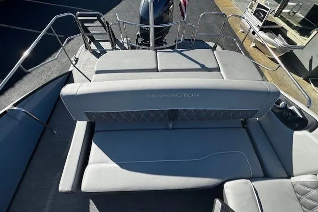 Slide: The Image of 2021 Bennington 23 LXS Swingback boat interior with gray seating and motor view. - 7