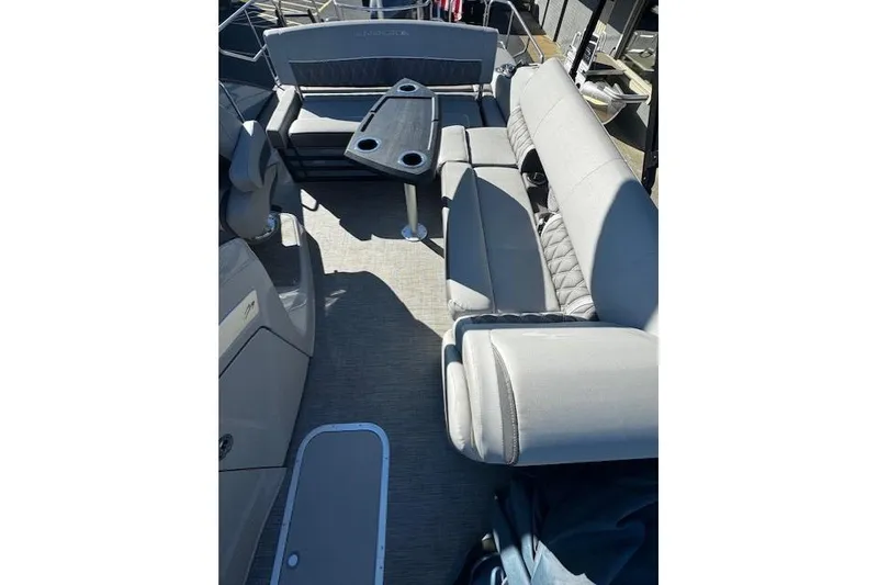 Slide: The Image of 2021 Bennington 23 LXS Swingback boat interior with gray seating and table. - 8