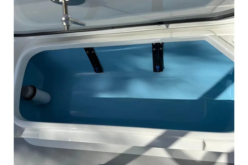 Slide: The Image of Livewell compartment of 2026 Shallow Sport 25 X3 boat, featuring a blue interior. - 10